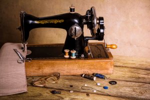 Alte Nähmaschine in schwarz mit Nähgarn